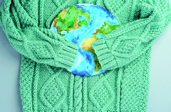 NGC | A green knitted sweater is wrapped around a round object painted to resemble a map of the Earth.