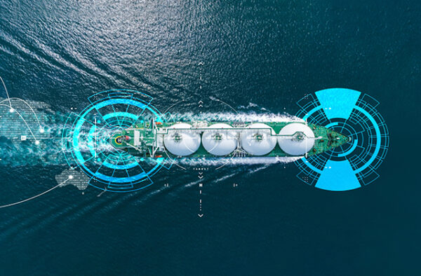 NGC | Aerial view of a ship carrying large white spherical containers, depicted with digital interface overlays on the ocean water.