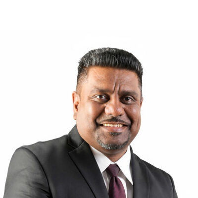 NGC | A man in a dark suit, white shirt, and maroon tie is smiling in front of a plain white background, representing the Board of Directors.